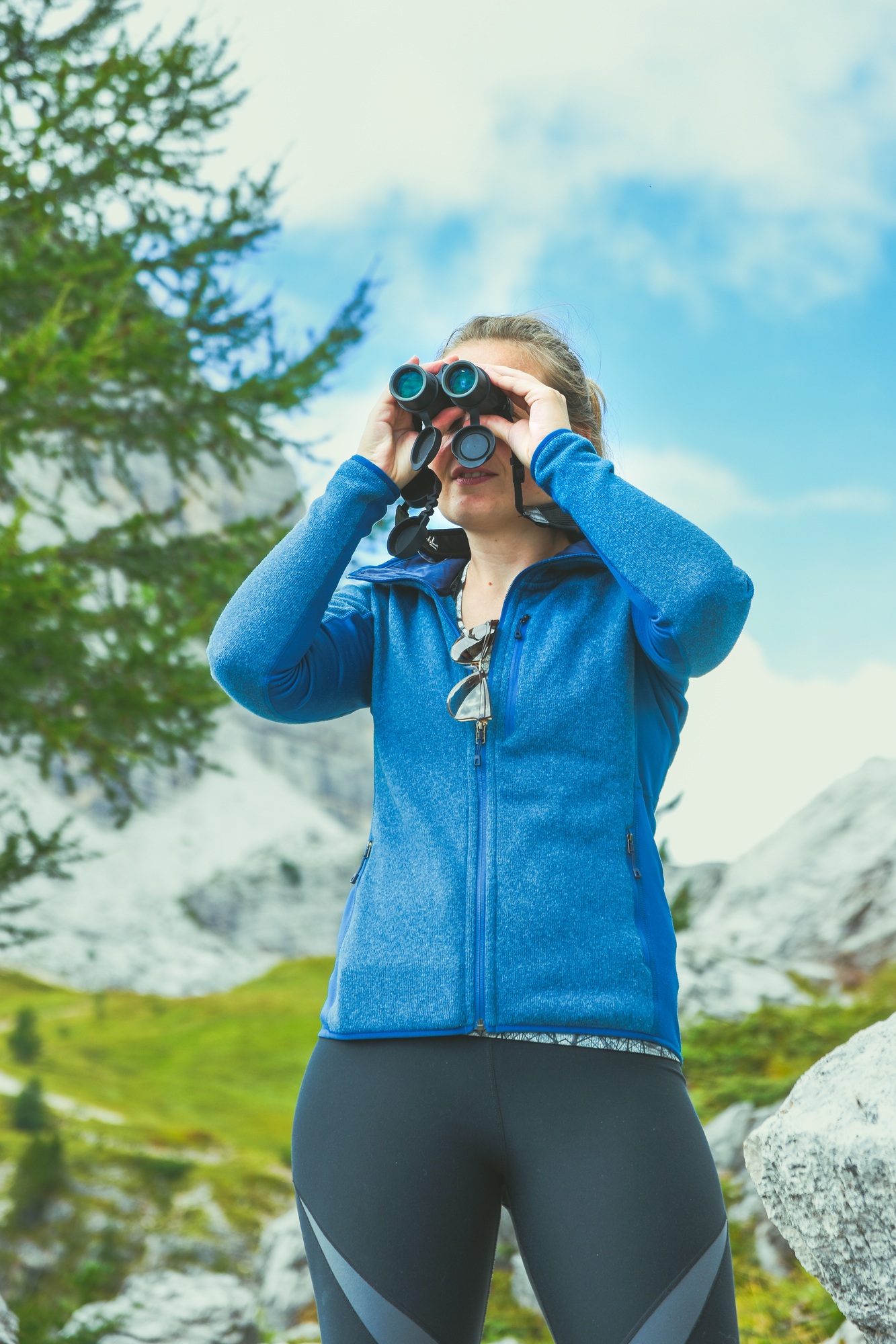 Looking through binoculars in the outdoors female travel adventure